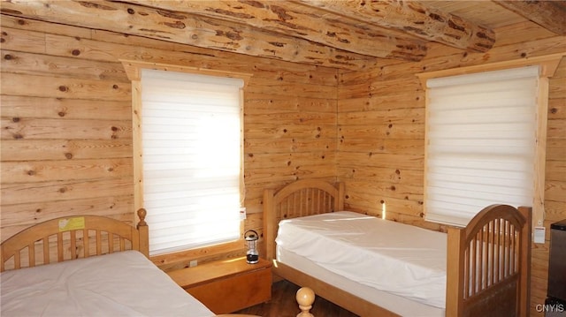 bedroom with wood walls and beamed ceiling