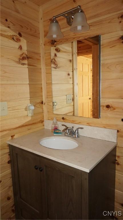 bathroom featuring vanity and wood walls