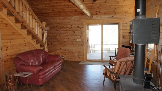 living area with a wood stove, wood walls, wooden ceiling, wood finished floors, and beamed ceiling