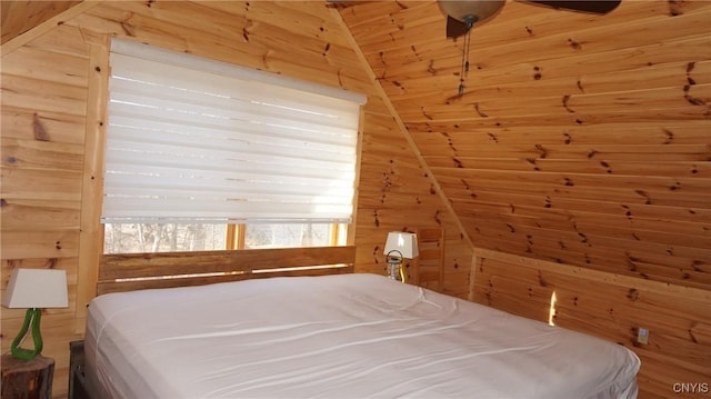 bedroom featuring ceiling fan, wood walls, wood ceiling, and lofted ceiling