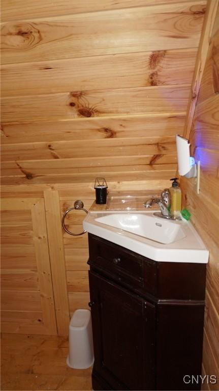 bathroom with vanity and wood walls