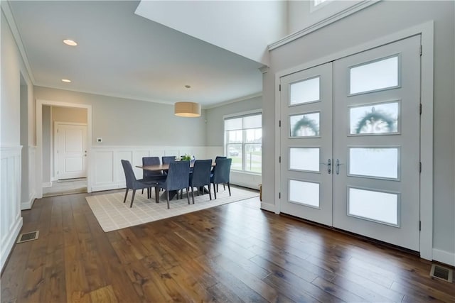 interior space featuring visible vents, dark wood finished floors, crown molding, and a wainscoted wall
