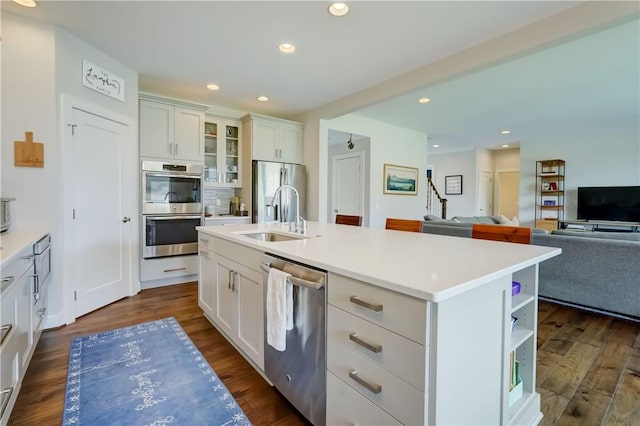 kitchen with open shelves, open floor plan, white cabinets, a sink, and stainless steel appliances