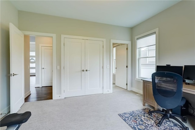 carpeted office space featuring baseboards