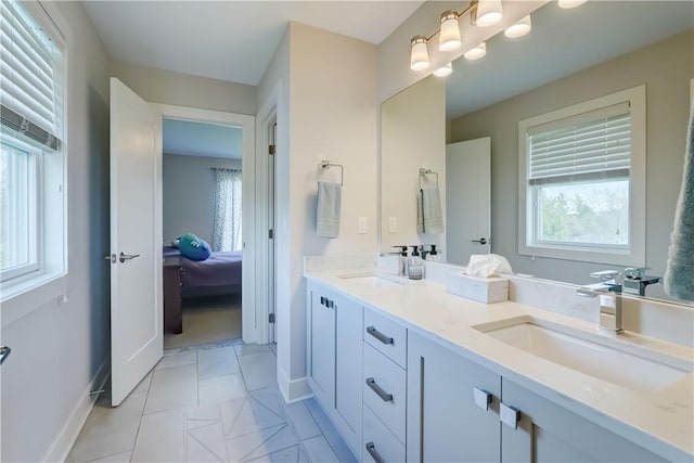 full bath with baseboards, a sink, and a healthy amount of sunlight