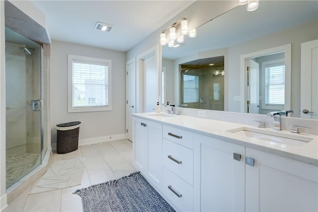 full bathroom featuring double vanity, tile patterned flooring, a stall shower, a sink, and baseboards