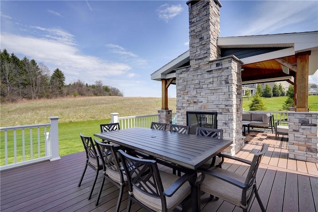 deck featuring a lawn, outdoor dining area, and an outdoor living space with a fireplace