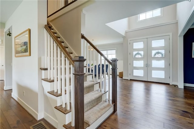 foyer entrance featuring stairs, baseboards, plenty of natural light, and dark wood-type flooring