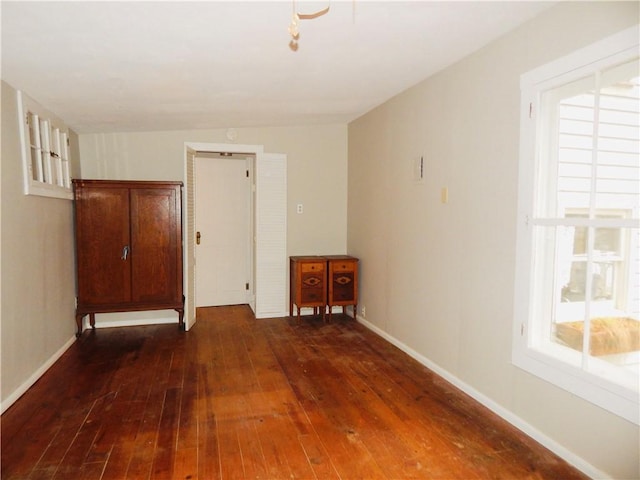 empty room featuring baseboards and hardwood / wood-style floors