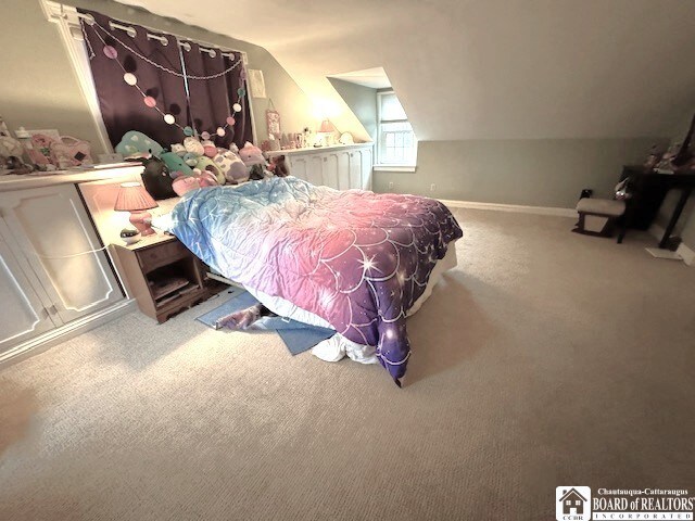 bedroom with carpet floors, baseboards, and vaulted ceiling