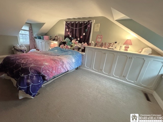 carpeted bedroom with lofted ceiling