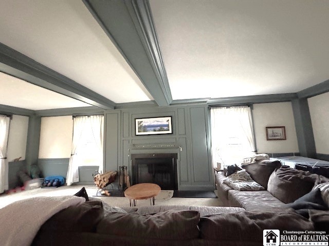 living room with a decorative wall, beamed ceiling, a wealth of natural light, and a fireplace