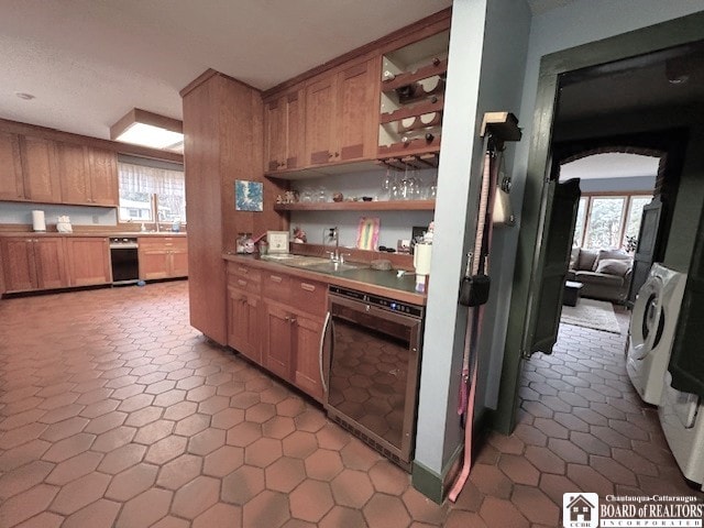 kitchen with beverage cooler, arched walkways, a sink, and a wealth of natural light