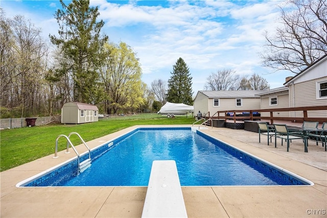 view of pool with fence, a patio, a shed, an outbuilding, and a yard