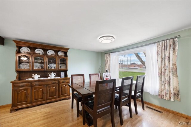 dining space with visible vents, light wood-style flooring, and baseboards