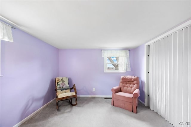living area with baseboards and light carpet