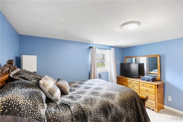 bedroom featuring baseboards and light carpet