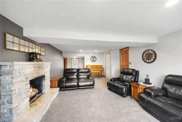 living area featuring light carpet, recessed lighting, and a stone fireplace