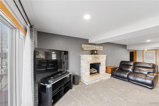 carpeted living area featuring a stone fireplace and recessed lighting