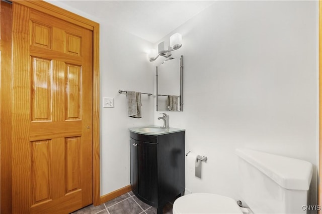 bathroom with toilet, baseboards, tile patterned flooring, and vanity