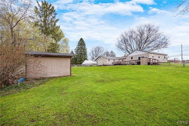 view of yard with fence and an outbuilding