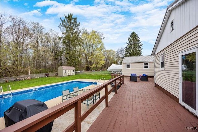 outdoor pool with a storage shed, a wooden deck, an outbuilding, an outdoor living space, and a lawn