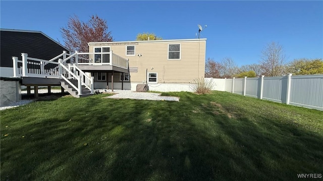 rear view of property with stairway, a deck, a yard, and a fenced backyard