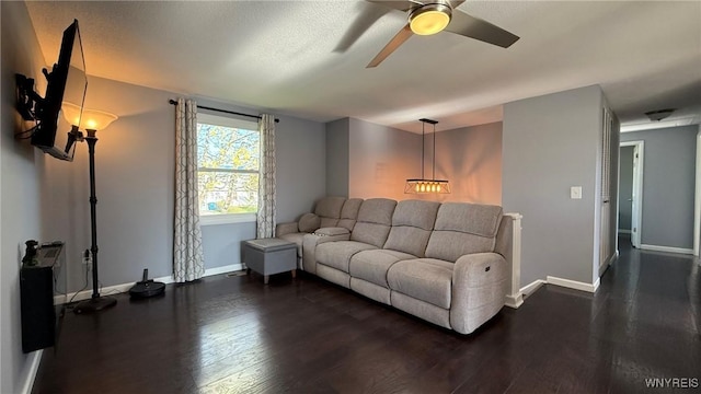 living room featuring baseboards, ceiling fan, and dark wood-type flooring