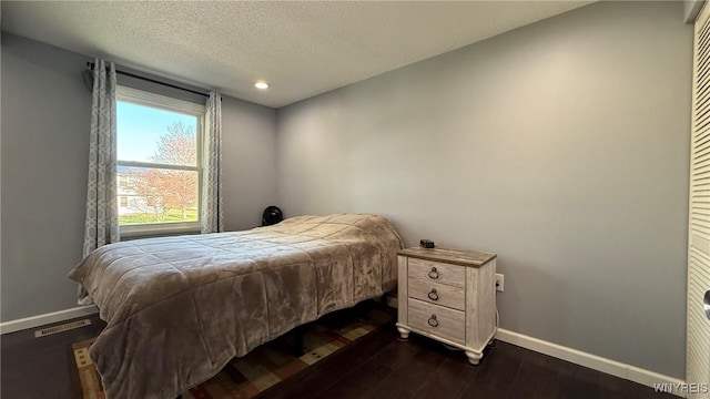 bedroom with baseboards, recessed lighting, dark wood finished floors, and a textured ceiling