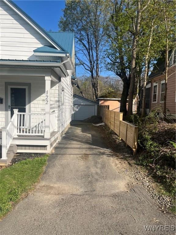 122 Main St, Hanover, NY 14136 - view of home's exterior with covered porch, fence, metal roof, an outbuilding, and a detached garage