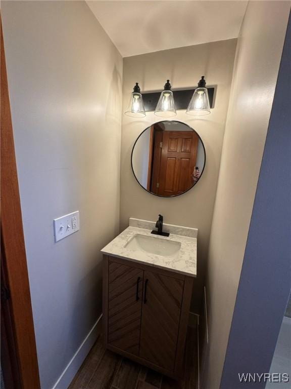 bathroom featuring baseboards, wood finished floors, and vanity