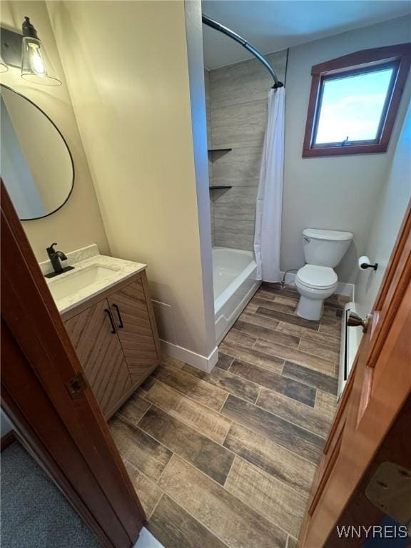 bathroom with toilet, baseboards, shower / bath combination with curtain, and vanity