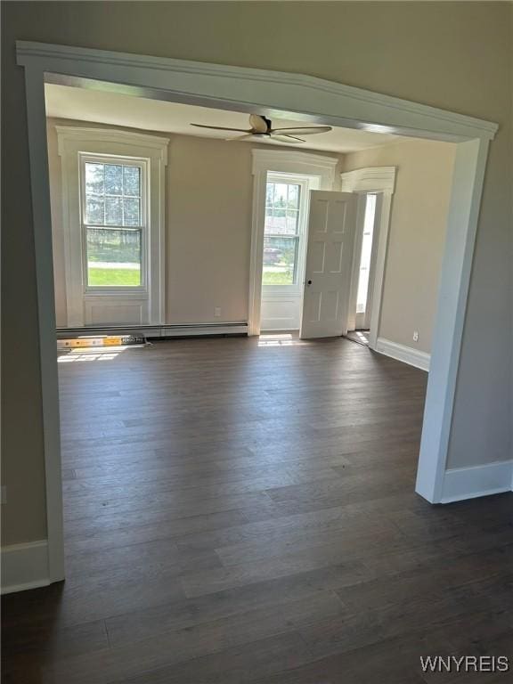 interior space with baseboards, a baseboard radiator, ceiling fan, and dark wood-style floors