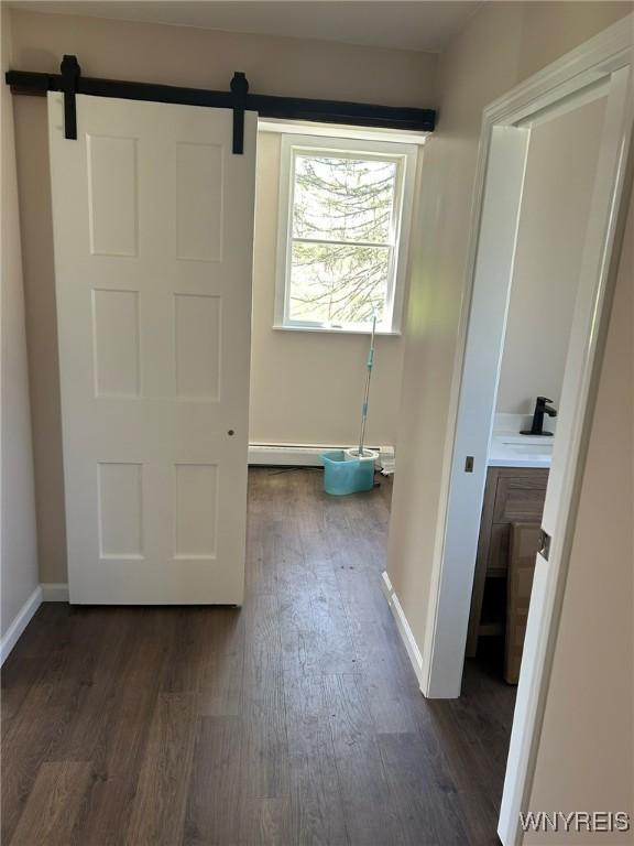 interior space with baseboards, wood finished floors, and baseboard heating