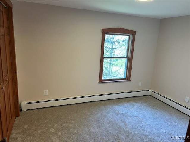 unfurnished room with carpet floors and baseboard heating