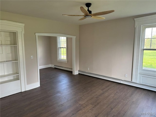 empty room with dark wood-type flooring, built in features, ceiling fan, and baseboard heating