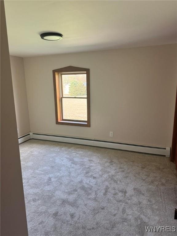 carpeted spare room with a baseboard radiator