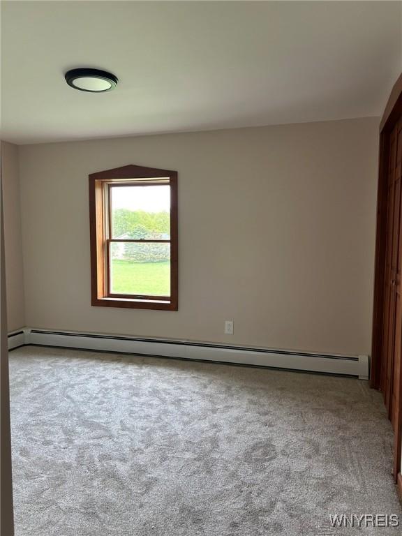 7310 Milestrip Rd, Orchard Park, NY 14127 - carpeted empty room with a baseboard radiator