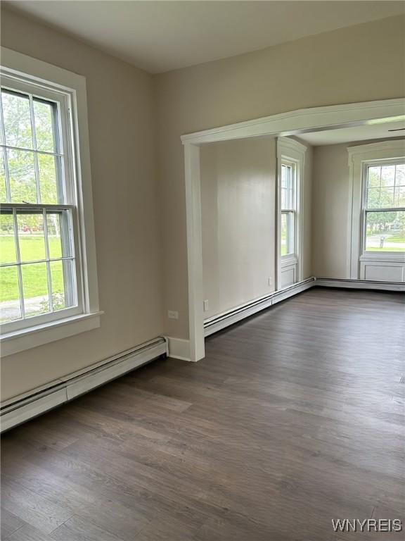 7310 Milestrip Rd, Orchard Park, NY 14127 - spare room with a baseboard radiator, dark wood-style flooring, and baseboards