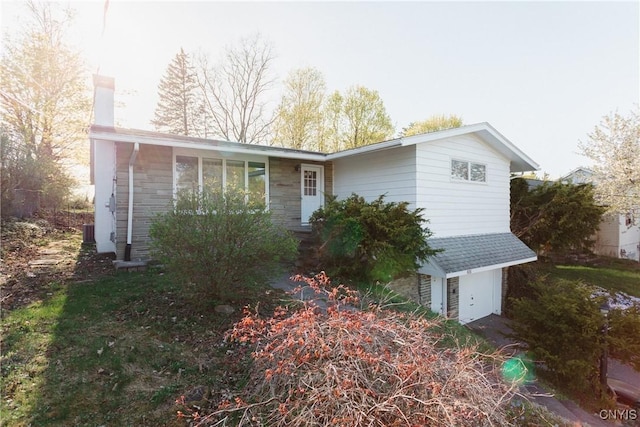 view of side of property with a chimney and stone siding