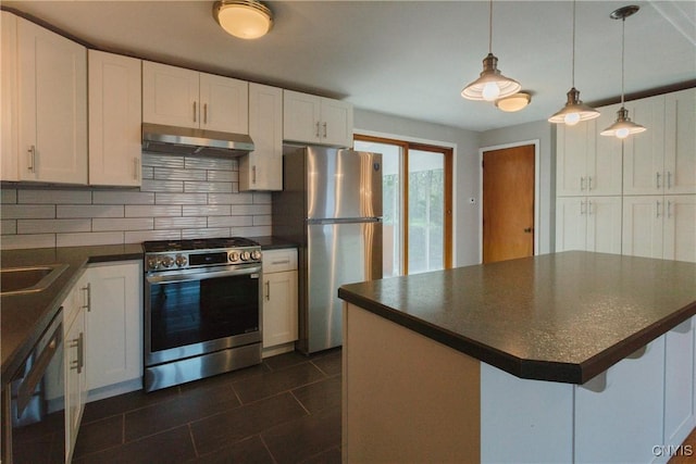 kitchen with decorative backsplash, dark countertops, under cabinet range hood, white cabinets, and stainless steel appliances