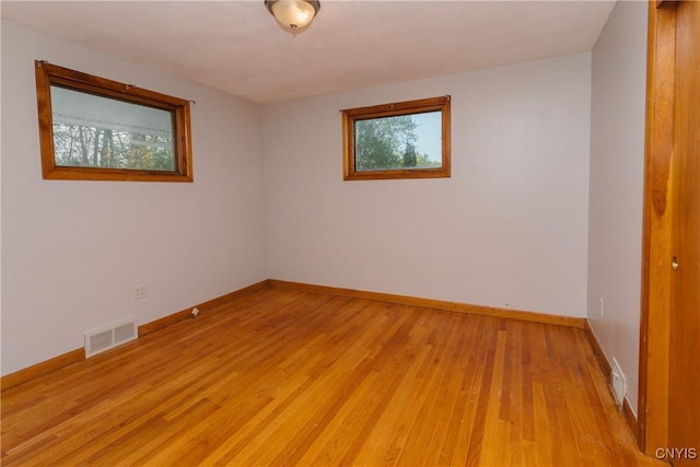 spare room with baseboards, visible vents, and light wood-style flooring
