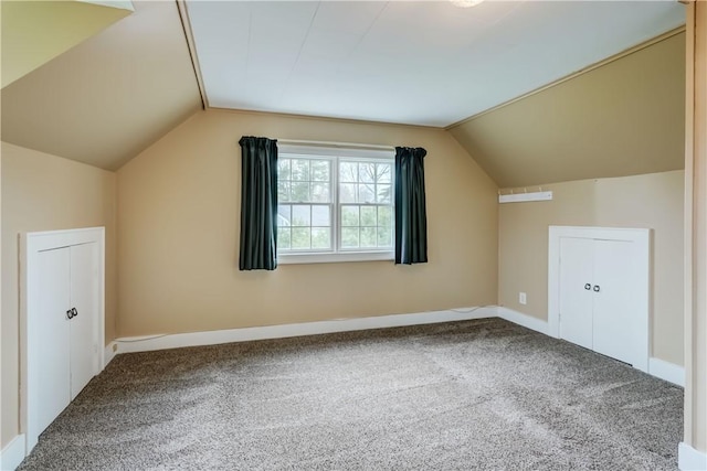 additional living space with baseboards, carpet flooring, and lofted ceiling