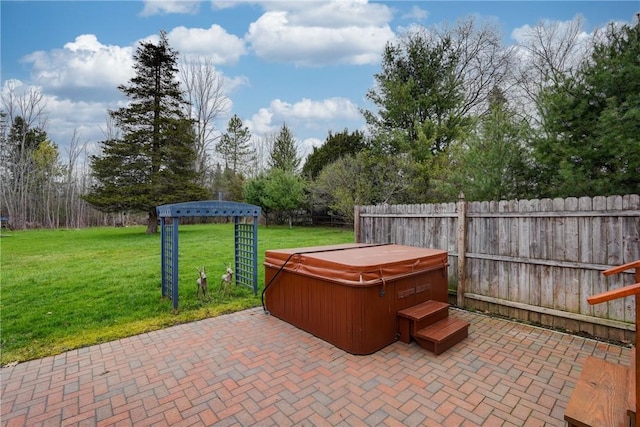 view of patio / terrace with a hot tub and fence