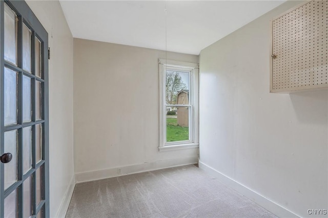 carpeted spare room featuring baseboards