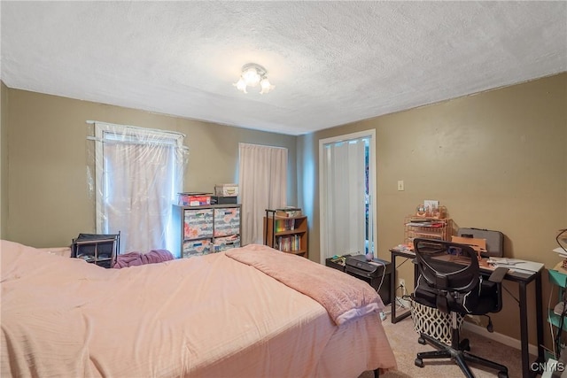 bedroom featuring a textured ceiling and light colored carpet
