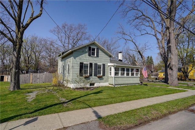 bungalow with fence, a chimney, and a front lawn
