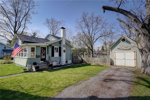 bungalow-style home featuring a chimney, a detached garage, fence, a front lawn, and entry steps