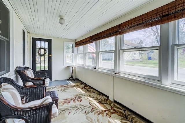 sunroom / solarium featuring wooden ceiling and concrete flooring