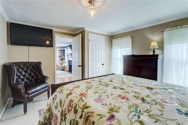 bedroom with crown molding and wood finished floors